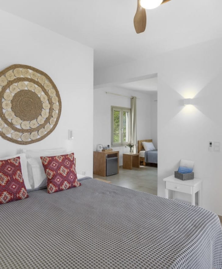 King size bed with woven wall piece and adjoining single bed room