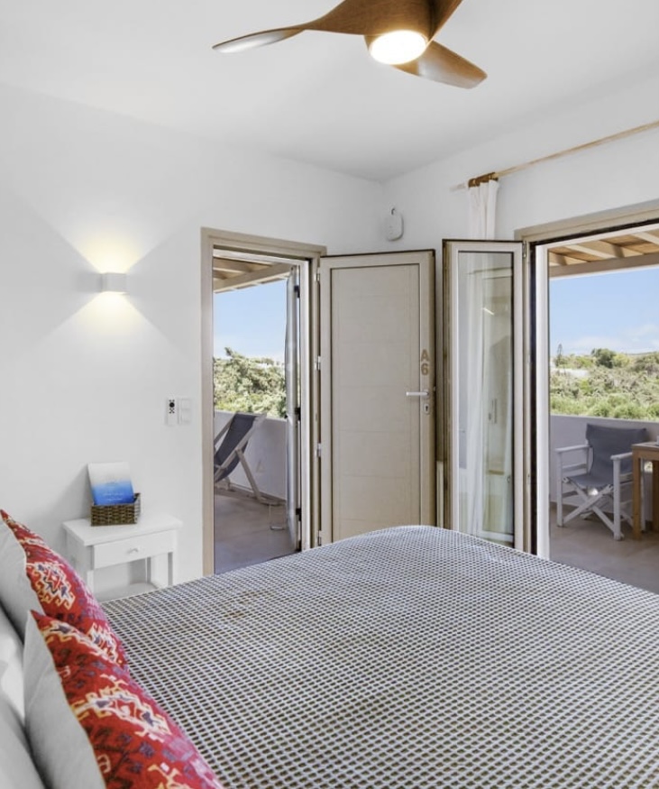 Bedroom with double balcony doors and sea breeze