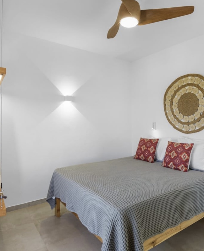 King size bed under a wooden ceiling fan