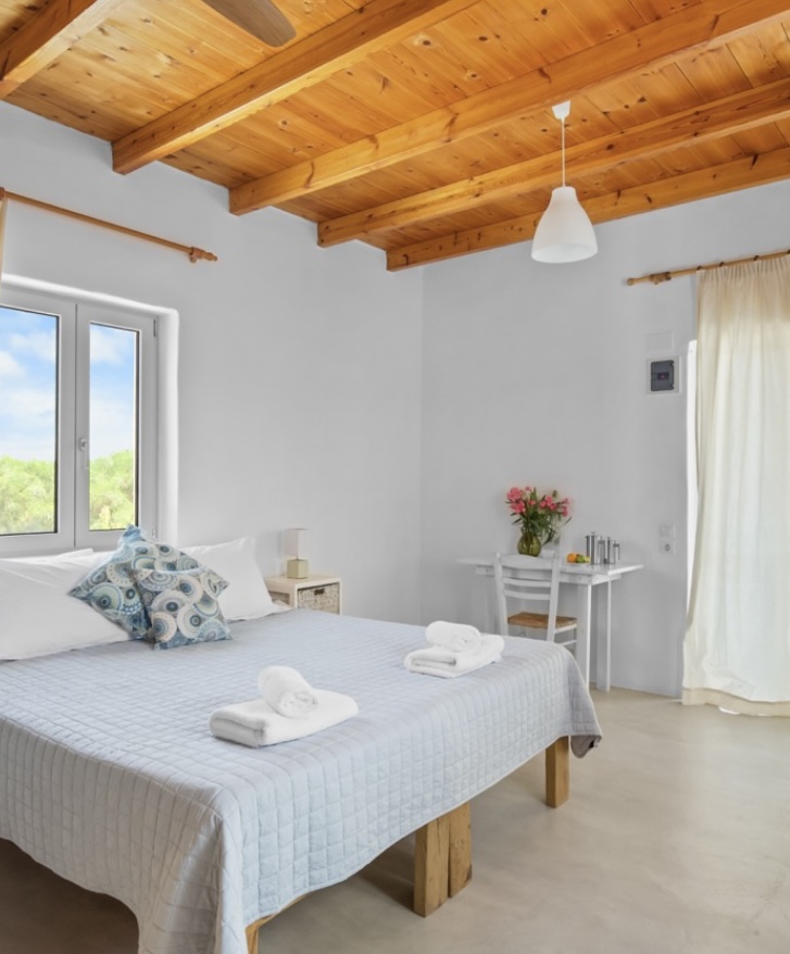 Bright bedroom with breakfast table and long white curtains