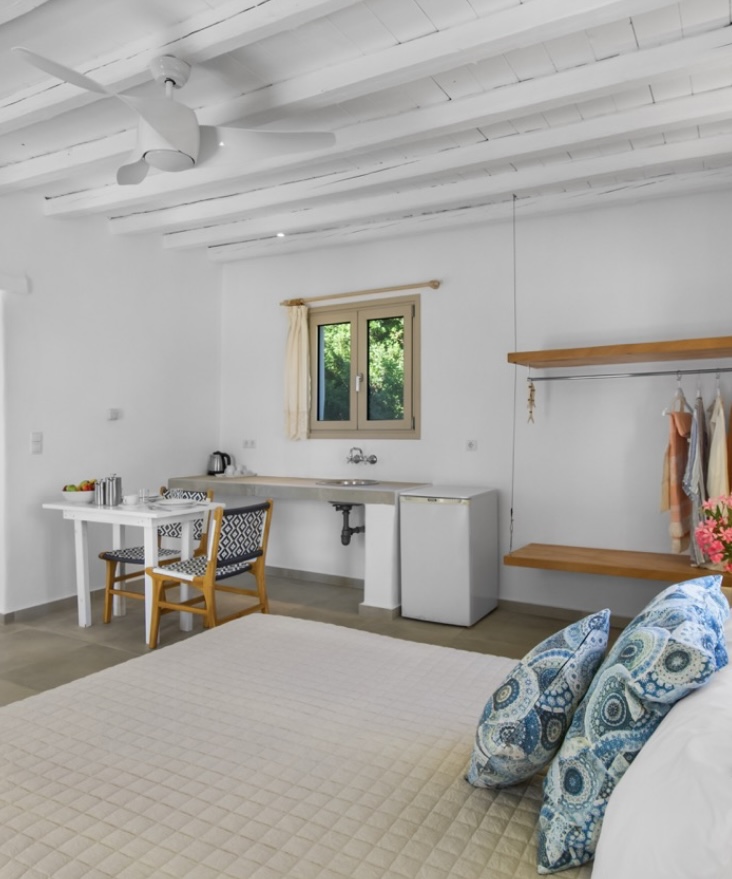 Kitchenette with dining table and bed with blue cushions