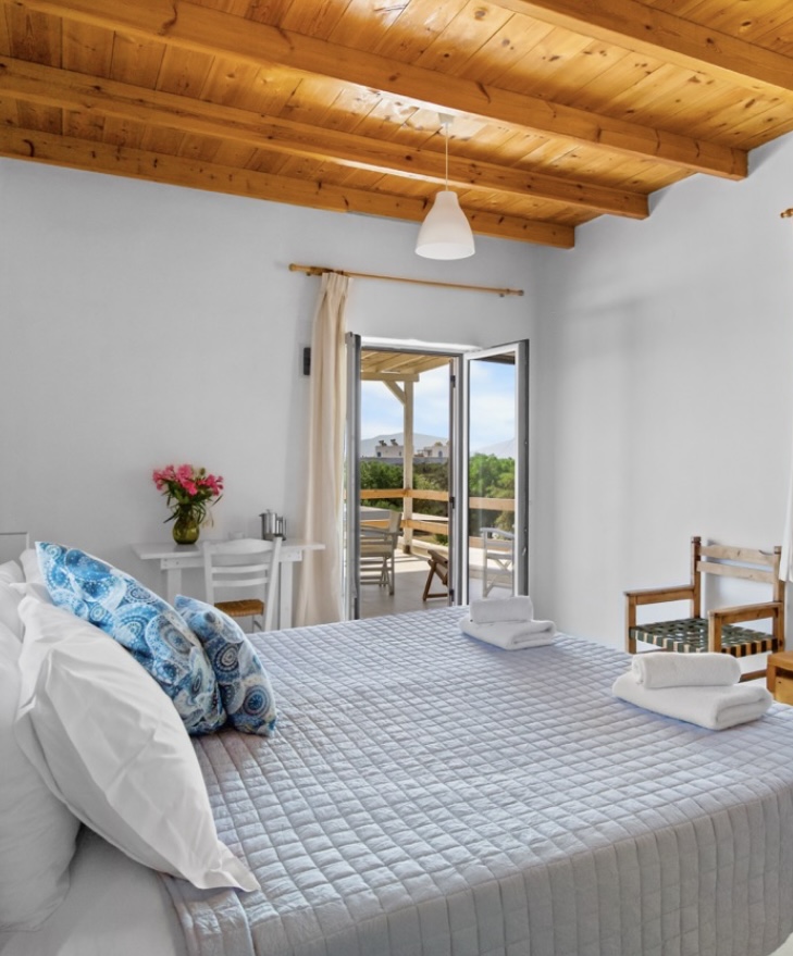 Double bed facing the balcony doors with sea and hill views