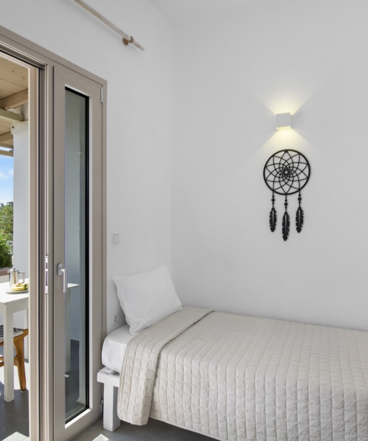 Single bed corner with dreamcatcher and balcony door