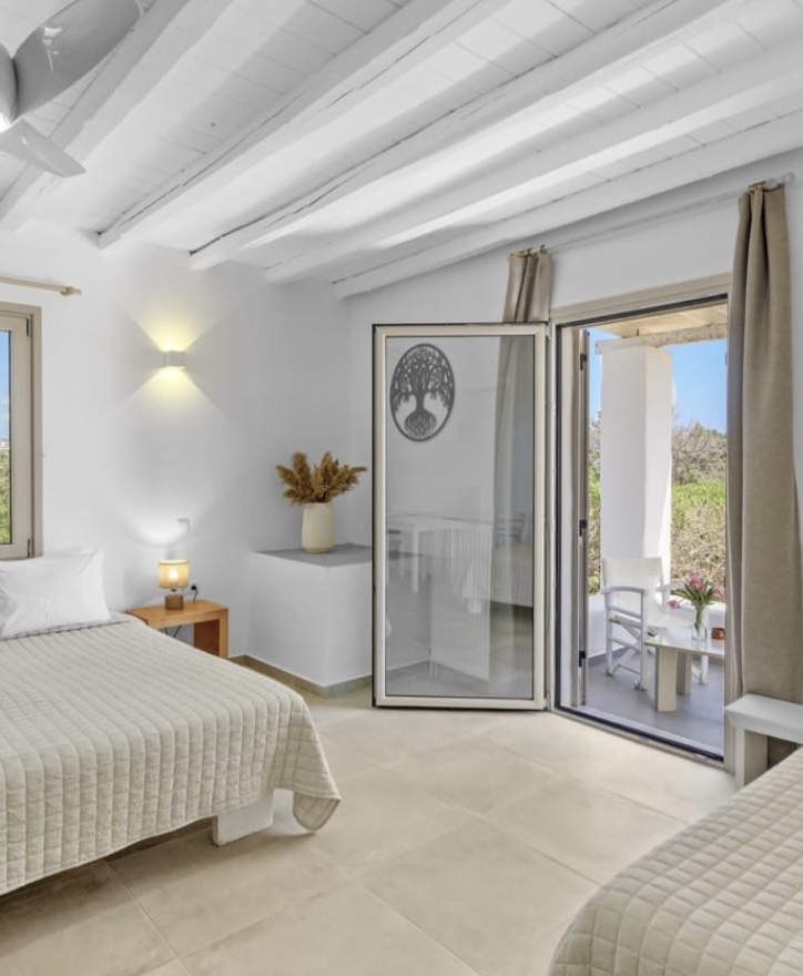 Bedroom with white beamed ceiling opening onto the balcony