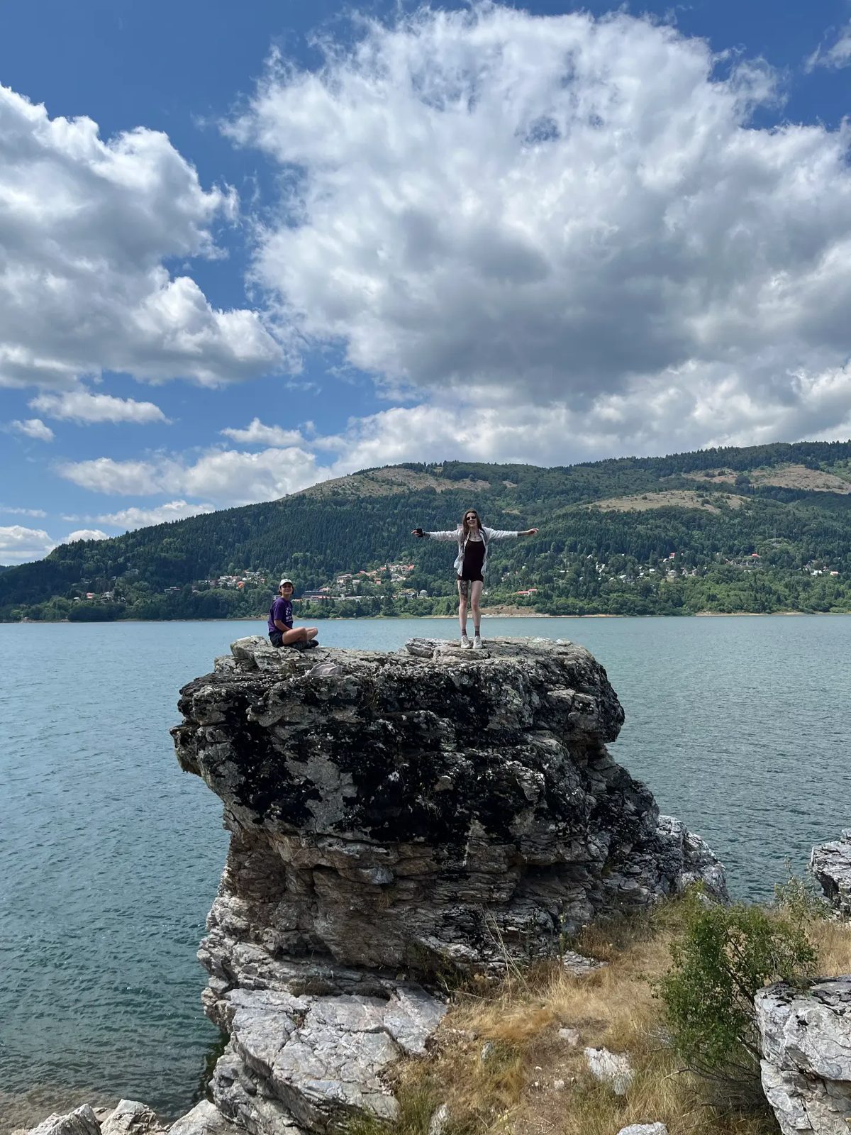 Arms open on a rock above Lake Mavrovo