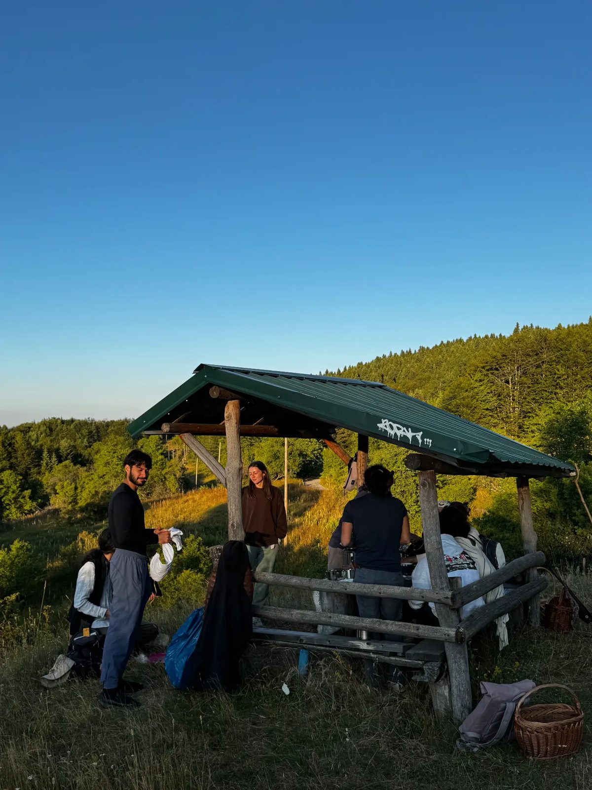 Sunset picnic under a wooden shelter in the hills