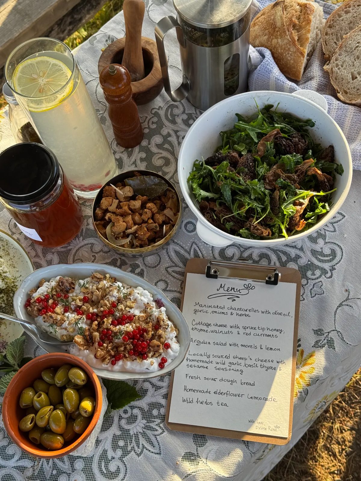 Wild-foraged table with handwritten menu at golden hour