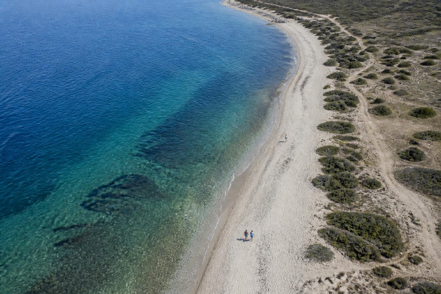 Aerial view of a Paros beach with turquoise water and a salt flat