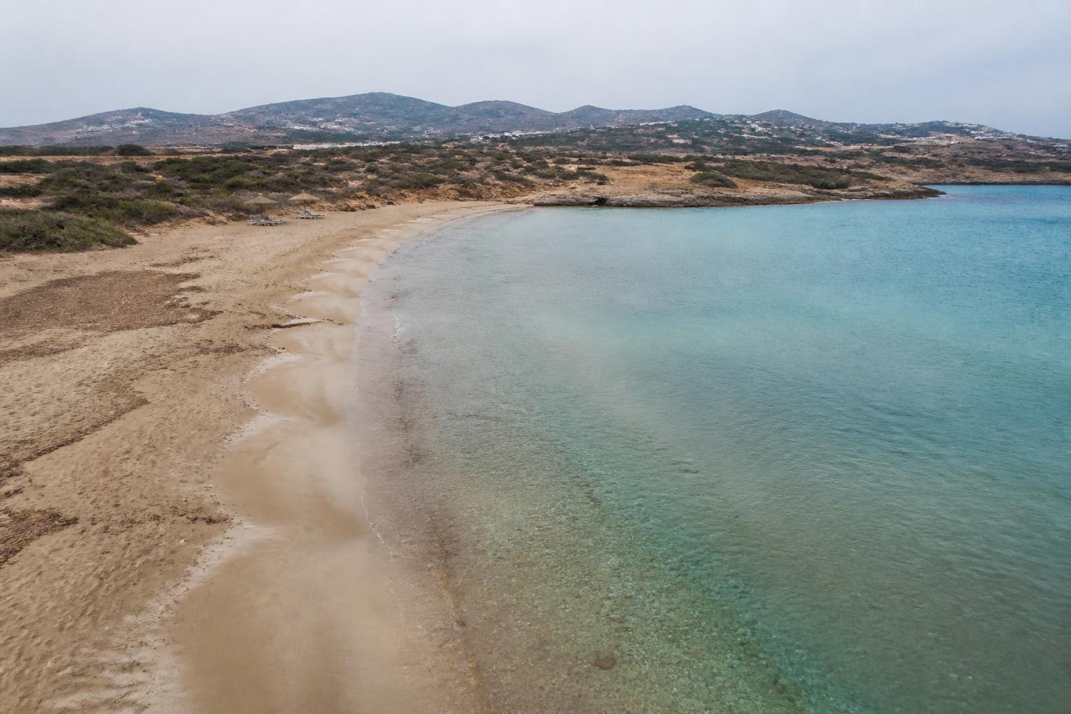 Aerial view of a beach on Paros with turquoise water and rocky coastline
