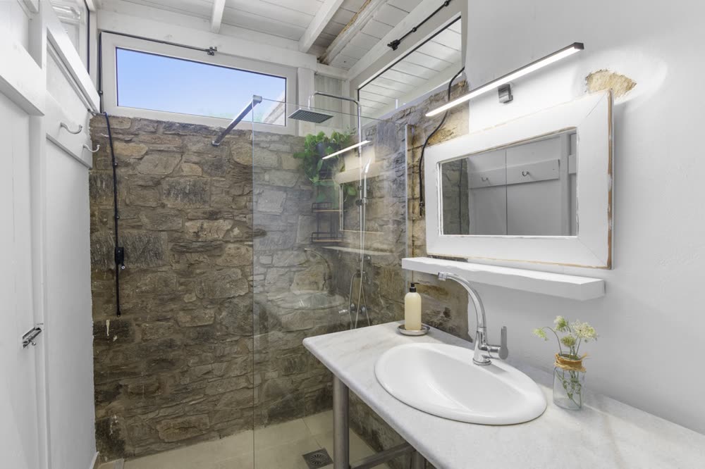 Bathroom with rain shower and natural stone wall