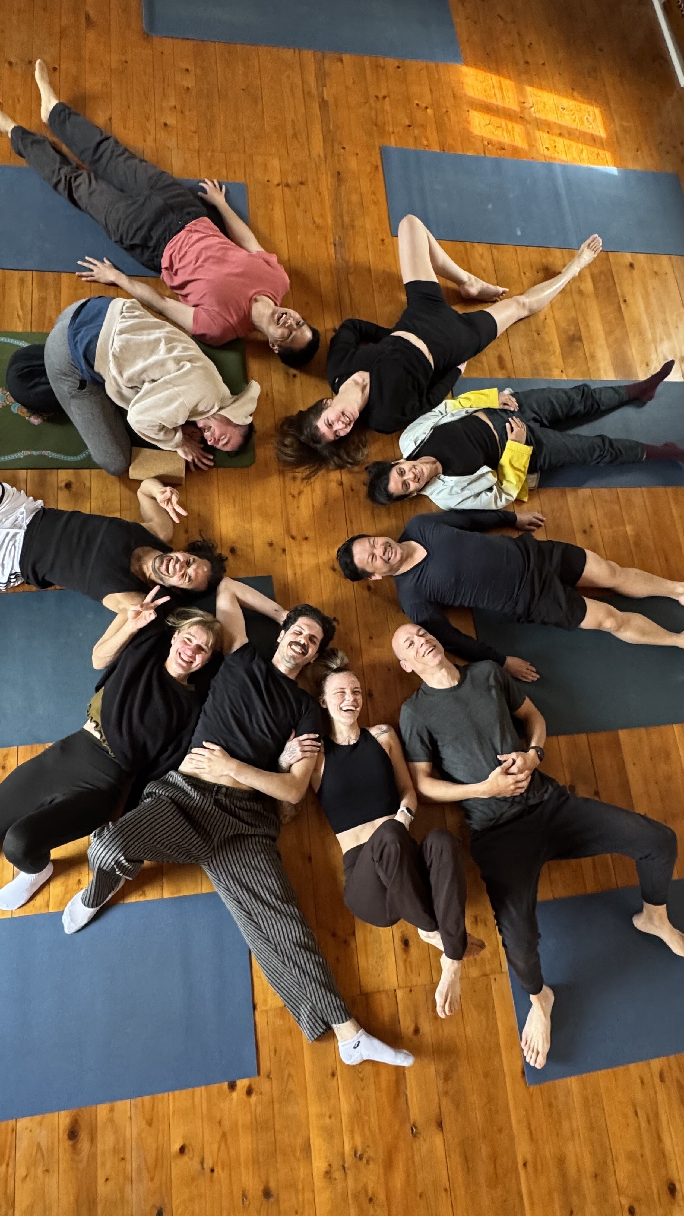 Group lying in a circle, smiling after class