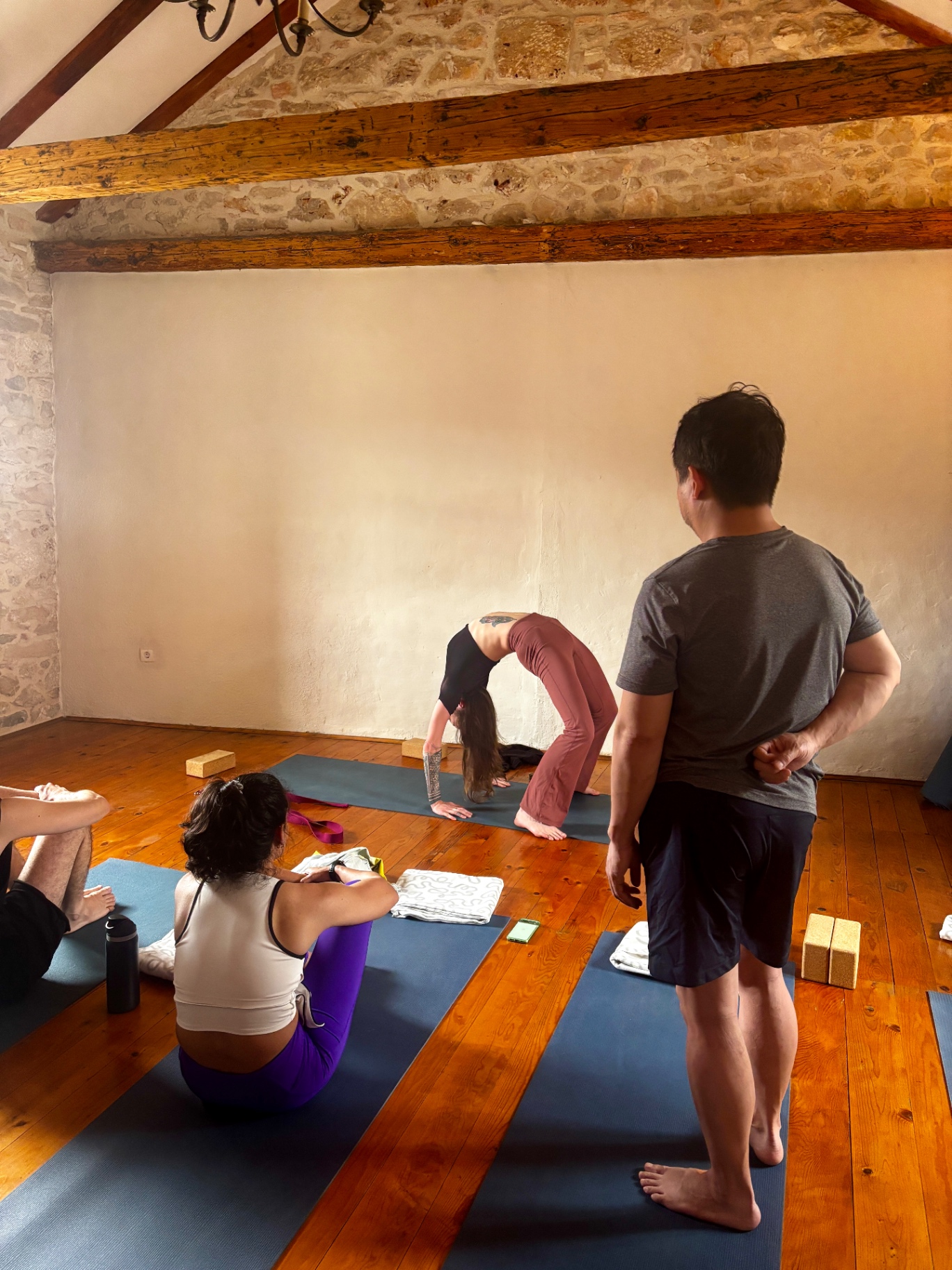 Bridge pose under wooden beams in the stone studio