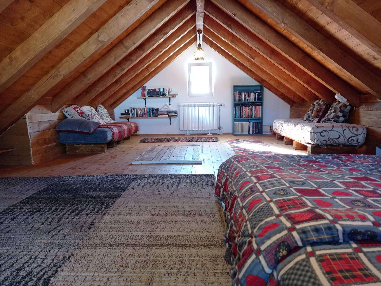 Cozy attic lounge with exposed wooden beams and bookshelves