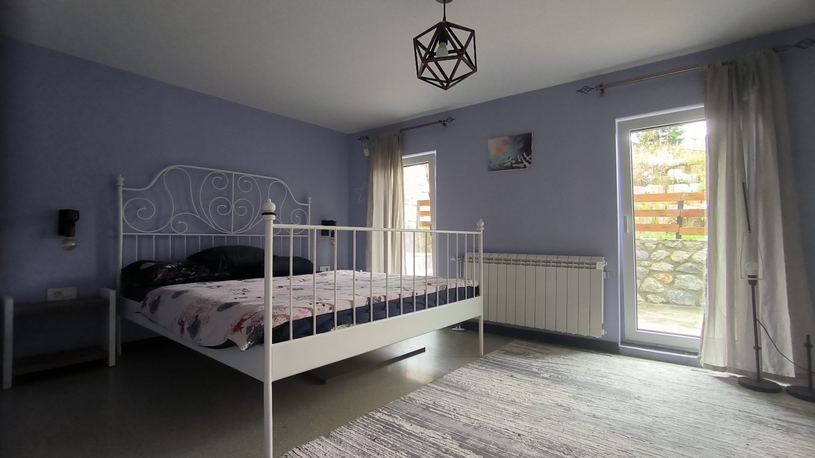 Villa bedroom with soft blue walls opening onto the garden