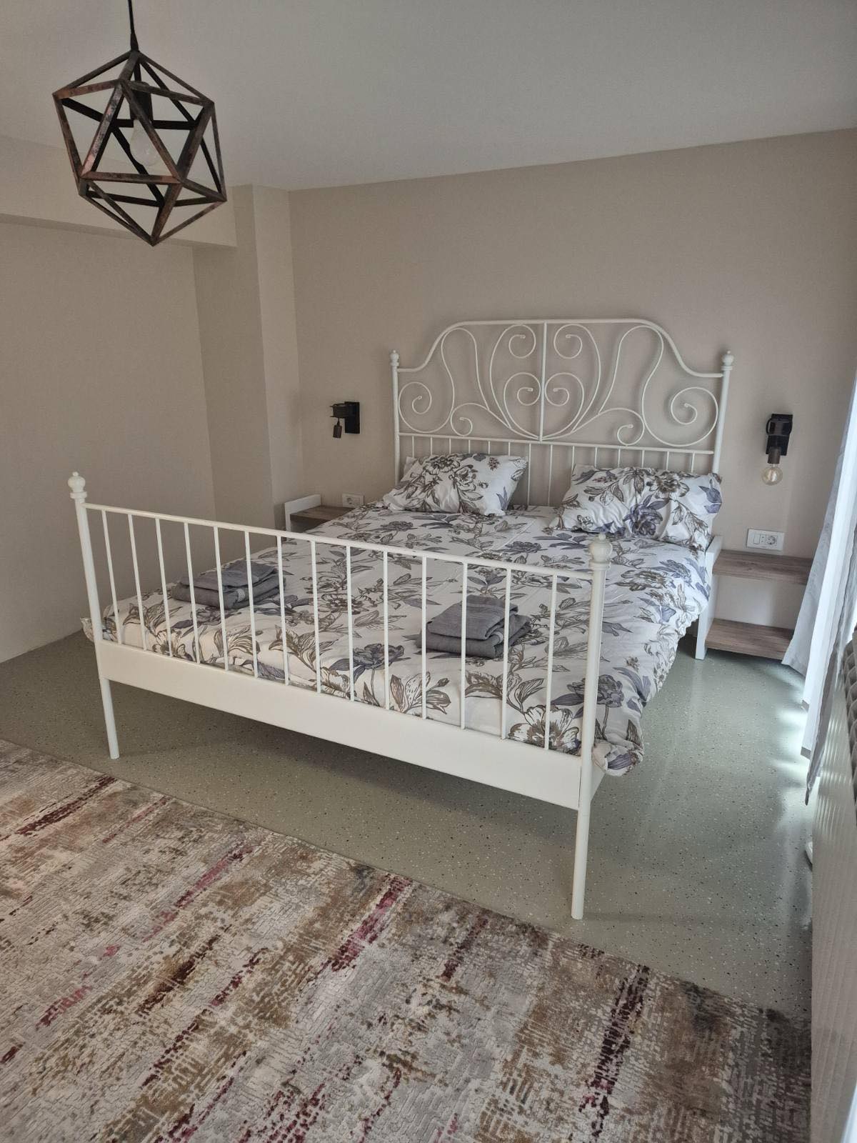 Villa bedroom with wrought-iron bed and floral linens